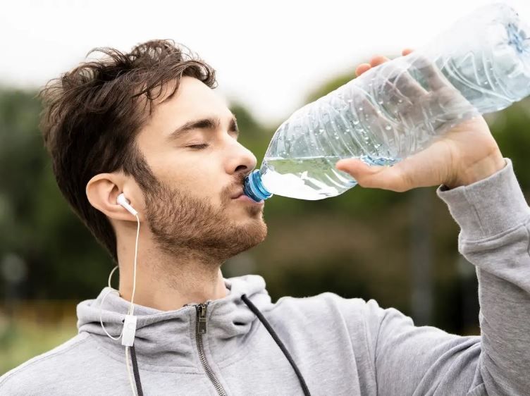 شخص يشرب الماء أثناء ممارسة الرياضة