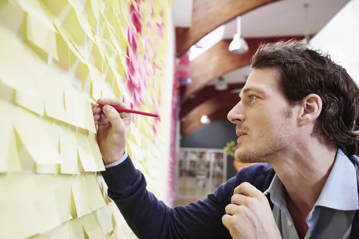 شخص يكتب الملاحظات على الحائط